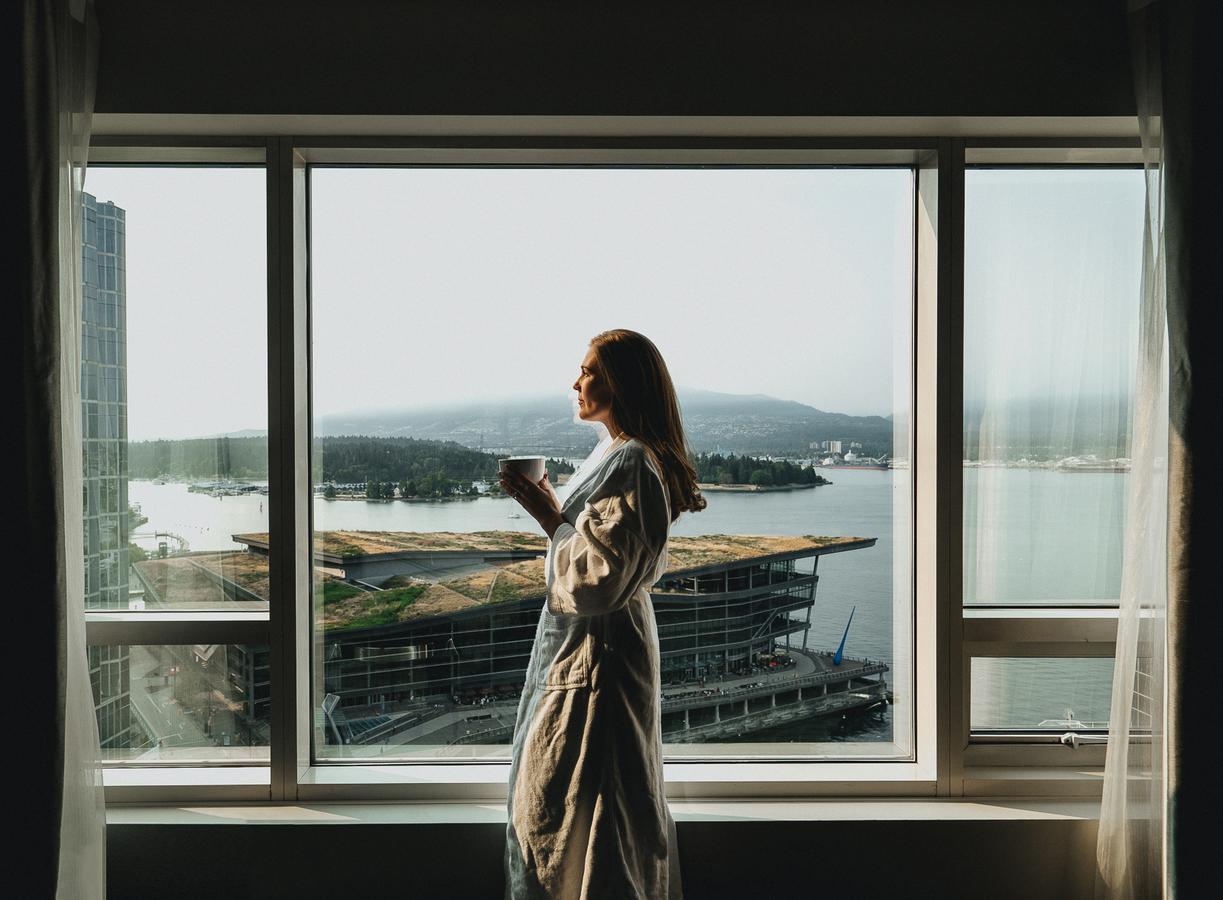 Fairmont Waterfront Hotel Vancouver Exterior photo A woman standing in front of a window